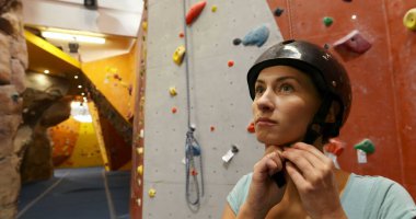 Fitness stüdyosunda koruyucu kask takan bir kadının portresi.