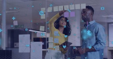 Ofiste beyin fırtınası yapan çeşitli erkek ve kadın meslektaşlar üzerine medya simgelerinin görüntüsü. Bağlantı, iş, ağ, takım çalışması ve iletişim, dijital olarak oluşturulmuş görüntü.