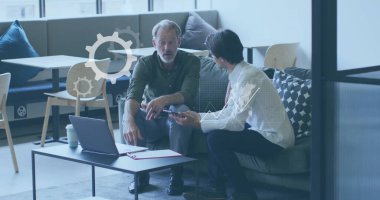 Ofisteki çeşitli iş adamları üzerinde dijital iş simgeleri ve veri işleme imajı. Küresel finans, iş, bağlantılar, hesaplama ve veri işleme kavramı dijital olarak oluşturuldu.