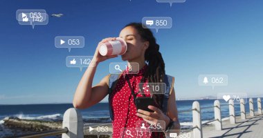 Kahve içen ve elinde akıllı telefon tutan, sosyal medya bilgilendirme görüntüsü olan bir kadın. technology, lifestyle, communication, connectivity, relaxation, digital