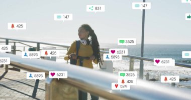 Sosyal medyada deniz kenarında yürüyen bir kadının görüntüsü yer alıyor. teknoloji, akıllı telefon, dijital, bağlantı, yaşam tarzı, açık hava