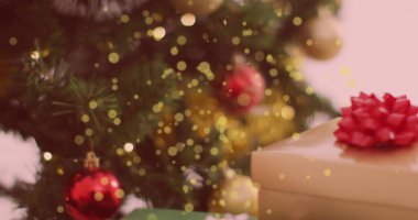 Süslü bir Noel ağacının ve hediyelerin üzerine düşen sarı ışık lekeleri. Noel şenliği ve kutlama konsepti