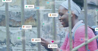 Akıllı telefon kullanan Afro-Amerikan bir kadın üzerinde ikonlar ve veri işleme görüntüsü. Küresel sosyal medya, bağlantılar, hesaplama ve veri işleme kavramı dijital olarak oluşturuldu.