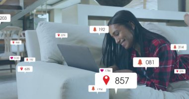 Dizüstü bilgisayar kullanan iki ırklı kadının ikonlar ve veri işleme görüntüsü. Küresel sosyal medya, bağlantılar, hesaplama ve veri işleme kavramı dijital olarak oluşturuldu.