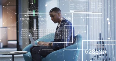 Ofisteki dizüstü bilgisayarla Afro-Amerikan iş adamının dijital veri işleme görüntüsü. Dijital olarak oluşturulmuş küresel bağlantılar, hesaplama ve veri işleme kavramı.