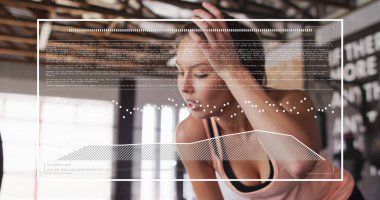 Spor salonunda egzersiz yapan melez bir kadının dijital veri işleme görüntüsü. Küresel spor, fitness, bağlantılar, hesaplama ve veri işleme kavramı dijital olarak oluşturuldu.