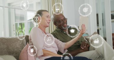 Koltukta tablet kullanan çiftler yerine eğitimi ve teknoloji imajını temsil eden simgeler. yenilik, öğrenme, dijital, bağlantı, ev, modern