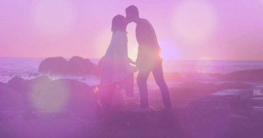 Deniz kenarında öpüşen melez bir çiftin üzerindeki ışık lekeleri. Yaşam tarzı, doğa ve dijital arayüz kavramı dijital olarak oluşturulmuş görüntü.