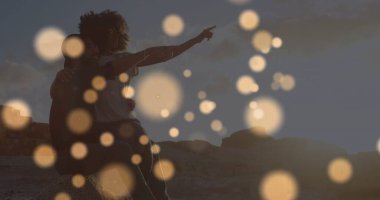 Deniz kenarında kucaklaşan melez çiftin üzerindeki ışık lekeleri. Yaşam tarzı, doğa ve dijital arayüz kavramı dijital olarak oluşturulmuş görüntü.