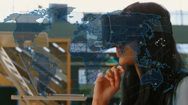 Sanal gerçeklik kulaklığı kullanarak, okulda küresel bir haritayla animasyon izleyen biri. Teknoloji, eğitim, yenilik, öğrenme, dijital, etkileşimli