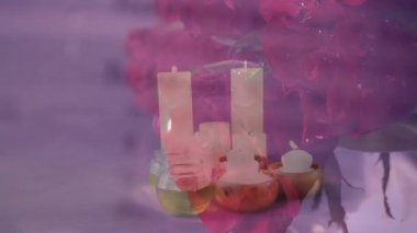 Mumlar ve pembe arkaplan üzerinde sözlük metni olan gerekli yağlar. Aromaterapi, rahatlama, parfüm, spa, sağlık, farkındalık.