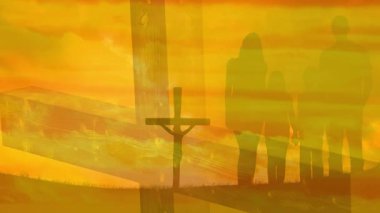 Canlı günbatımında canlı günbatımına karşı haçın yanında duran siluetli aile. Birliktelik, ruhsal bağ, manzara