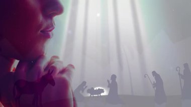 İsa 'nın doğumu sahnesi ve ışık ışınları ile dua eden kişi animasyon etkisi yaratıyor. Maneviyat, inanç, ibadet, Noel, din, meditasyon