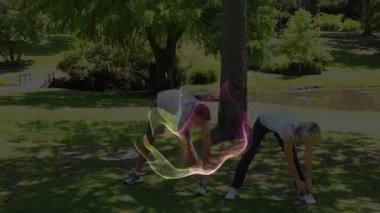 İnsanlar renkli dijital dalga animasyonlarıyla parkta geriniyorlar. Açık hava, fitness, dijital sanat, egzersiz, sağlık, teknoloji