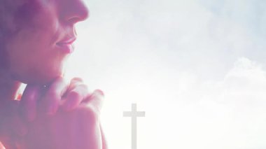 Huzurlu, yumuşak arka plan animasyonuna karşı haçla dua eden kişi. Tapma, maneviyat, meditasyon, inanç, tefekkür, barış