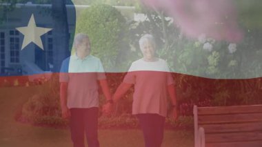 Şili bayrağı animasyonunda el ele tutuşmuş yaşlı bir çift bahçede yürüyor. Yaşlılar, bahçıvanlık, doğa, aşk, ulusal, açık hava