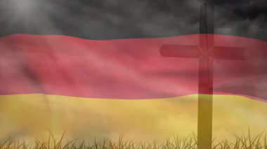 Çimen tarlasında Alman bayrağı sallarken ön planda çapraz siluet vardı. Vatanseverlik, ulusal gurur, sembolizm, maneviyat, miras, kimlik