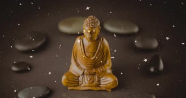 Buda heykelini çevreleyen yüzen yıldızlar animasyon ortamında pürüzsüz taşların üzerinde. Meditasyon, maneviyat, sükunet, zen, uyum, sükunet