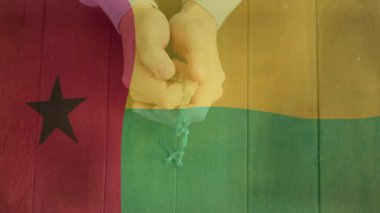Elinde tespih, Gine-Bissau bayrağını animasyon unsurlarıyla birlikte teslim et. Din, maneviyat, inanç, dua, kültür, vatanseverlik