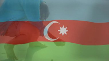 Sahilde çömelmiş, elinde Azerbaycan bayrağı animasyonu olan küçük bir nesne tutuyor. Deniz kenarı, vatanseverlik, ulusal, kıyı, dinlenme, rahatlama