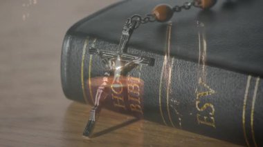İmanı ve kutsal kitabı sembolize eden, animasyona odaklanan tespih boncuklu İncil. Din, maneviyat, ibadet, kutsal, meditasyon, dua