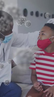 Koronavirüs covid 19 salgın konsepti dijital olarak üretilen video konsepti sırasında virüs hücrelerinin Afro-Amerikan erkek doktor test çocuğu üzerinde animasyonu..