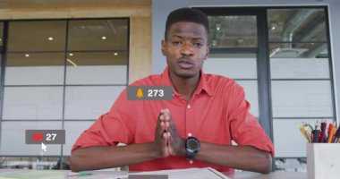 Sosyal medya bilgilendirme ikonlarıyla çevrili kırmızı gömlekli adam ofiste çalışıyor. Teknoloji, iletişim, çoklu görev, dijital, bildirimler, işyeri