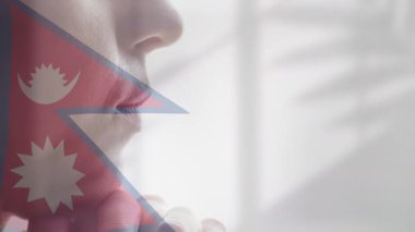 Nepal bayrağı üstüste koyan düşünceli biri, hafif ışıklandırmada canlandırma etkisi. İçgözlem, tefekkür, vatanseverlik, milliyet, gurur, meditasyon