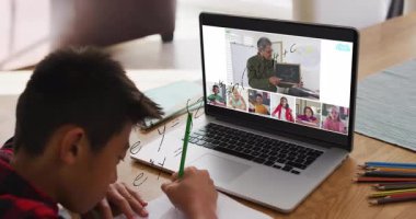 Okulda, çocuk dizüstü bilgisayarında animasyon kullanarak öğretmen ve sınıf arkadaşlarıyla matematik çalışıyor. Eğitim, teknoloji, öğrenme, dijital, işbirliği, sınıf