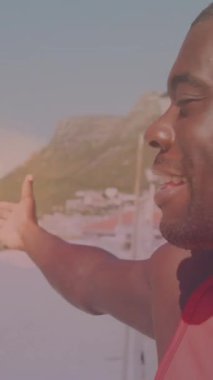 Sahilde gülümseyen Afrikalı Amerikalı bir adamın üzerinde ışık lekeleri. sağlık ve zindelik kavramı dijital olarak oluşturulmuş video.