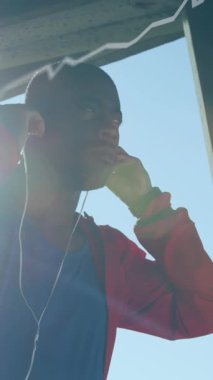 Dışarıda kulaklık takan Afro-Amerikan bir adama karşı istatistiksel veri işleme. spor ve spor konsepti