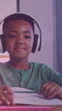 Işıkların animasyonu, kulaklık takan ve ödev yapan mutlu Afrikalı Amerikalı çocuk üzerinde. çocukluk, eğitim ve sorumluluklar konsepti dijital olarak oluşturulmuş video.