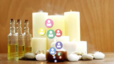 Mumların ve temel yağların üzerinde yüzen renkli kullanıcı simgelerinin canlandırılması. Sağlık, rahatlama, aromaterapi, meditasyon, spa, sükunet.