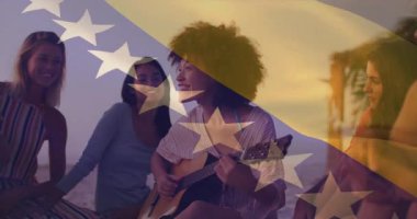 Sahilde, arka planda bayrak animasyonuyla müzik dinleyen kadınlar vardı. Tatil, rahatlama, rahatlama, teknoloji, kulaklık, ulusal