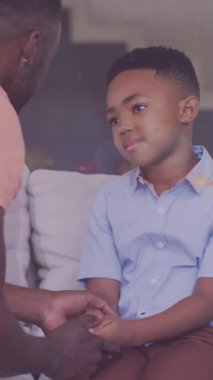 Afrika kökenli Amerikalı baba ve oğulun ciddi bir konuşma yaparken ışıkların animasyonu. aile, birliktelik, kaliteli zaman konsepti dijital olarak oluşturulmuş video.