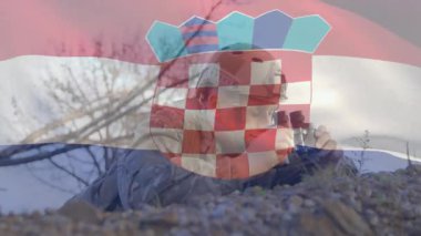 Dürbün kullanan Hırvat bayraklı asker, açık hava animasyon sahnesine çıktı. Ordu, vatanseverlik, kamuflaj, gözetleme, savunma, açık hava.