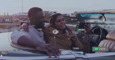 Üstü açık araçta, bir çift animasyon sırasında deniz kenarından geçerken bildirimleri kontrol ediyor. Seyahat, özgürlük, teknoloji, yaz, macera, yolculuk