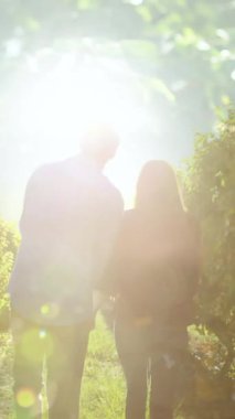 Beyaz tenli bir çiftin el ele tutuşup üzüm bağında yürümesinin animasyonu. şarap işi, kutlama ve birlikte zaman geçirme konsepti dijital olarak oluşturulmuş video.