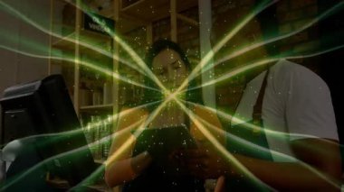 Tezgahta çalışan insanlar üzerinde yeşil enerji dalgası animasyonu. Sürdürülebilirlik, çevre dostu, işyeri, teknoloji, perakende, takım çalışması