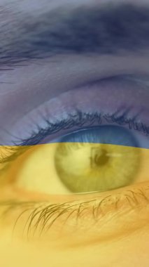 Kafkasyalı bir kadının açık gözünün üzerinde dalgalanan Ukrayna bayrağının animasyonu. Ukrayna krizi ve uluslararası politika kavramı dijital olarak oluşturuldu.