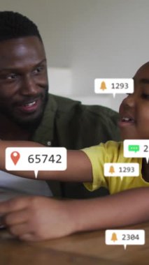 Oğlu dizüstü bilgisayar kullanan Afro-Amerikan baba medya simgelerinin animasyonu. Sosyal medya ve iletişim arayüzü kavramı dijital olarak oluşturulmuş video.