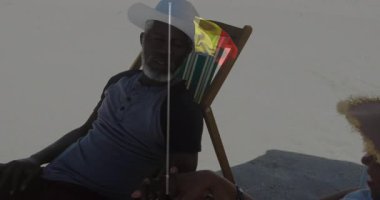 Plaj sandalyelerinde dinlenen, güneş şapkası takan ve günlük giysiler giyen yaşlı bir çift. Tatil, tatil, rahatlama, yaz, seyahat, tropik