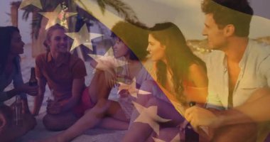 Sahilde oturan, yıldız animasyonu yapan bir grup arkadaş. Arkadaşlık, açık hava, tatil, yaz, boş zaman, mutluluk.