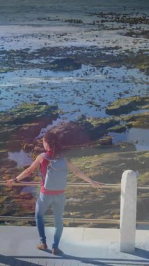 Gezinti güvertesindeki görüntüye hayran olan melez kadının üzerindeki ışık lekelerinin canlandırılması. sağlık ve zindelik kavramı dijital olarak oluşturulmuş video.