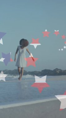 Sahilde elini kaldıran Afro-Amerikan kadının üzerinde Amerikan bayrağı ve yıldızların canlandırılması. Vatanseverlik ve kutlama konsepti dijital olarak oluşturulmuş video.