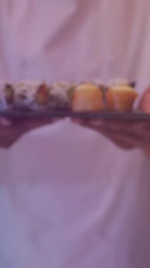 Suşi tutan çift ırklı erkek aşçının animasyonu. Sosyal medya ve iletişim arayüzü kavramı dijital olarak oluşturulmuş video.