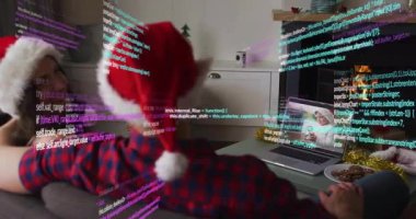 Noel Baba şapkası takan kişi renkli kod animasyon kaplamalı dizüstü bilgisayarı izliyor. Teknoloji, kodlama, dijital, festival, programlama, tatil