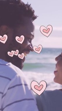 Animation of heart icons over african american couple on beach. fashion and lifestyle concept digitally generated video.