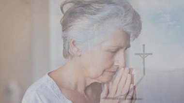 Kilisede çarmıhın önünde eli kolu bağlı dua eden yaşlı bir kadın. İbadet, maneviyat, inanç, bağlılık, din, dua
