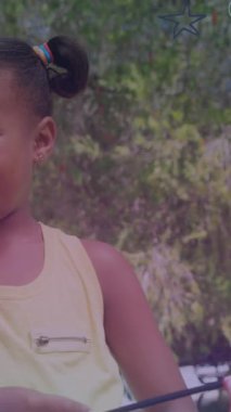 Kızları Amerikan bayraklarını sallayan mutlu Afro-Amerikan babası yerine yıldızların animasyonu. Uluslararası Aileler Günü ve dijital olarak üretilen video konsepti.